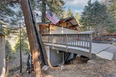 a house with a wrap around deck in the woods at 3 Mi to Lake Arrowhead Village Pine-View Home! in Lake Arrowhead
