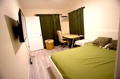 a bedroom with a green bed and a table and a desk at Walk of Fame 1 Bedroom with shared bathroom and kitchen in Los Angeles