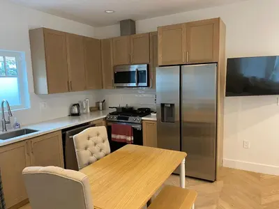 a kitchen with a table and a stainless steel refrigerator at Guest House in Los Angeles
