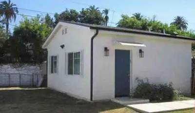 a small white building with a blue door at Guest House in Los Angeles