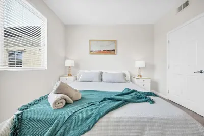 a white bedroom with a bed with a blue blanket on it at Lux Oasis in Woodland Hills in Los Angeles