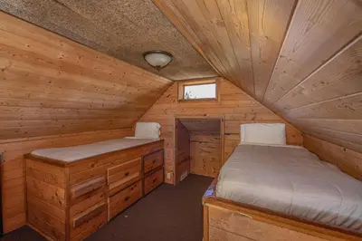 a room with two beds in a log cabin at Big Bear Lakefront Lodge in Big Bear Lake