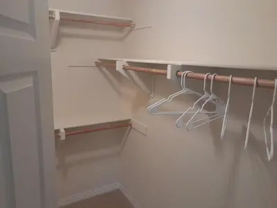 a walk in closet with white walls and wooden hangers at Great place for good night rest in Anaheim