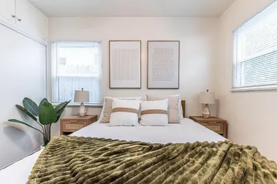 a bedroom with a large bed and two windows at 3BR Santa Monica Home, Ideal for Groups! in Los Angeles
