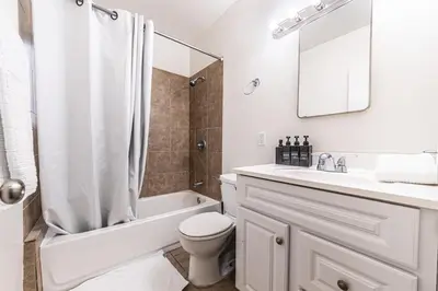 a white bathroom with a tub and a toilet and a sink at 3BR Santa Monica Home, Ideal for Groups! in Los Angeles