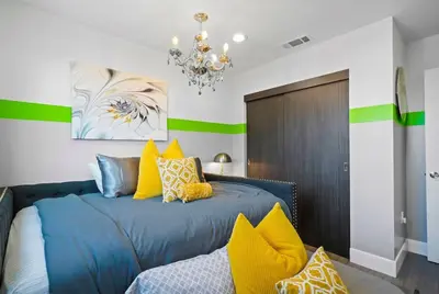 a bedroom with a blue bed with yellow pillows at C- Vibrant and Glam NoHo Pad near U-Studios and H-Sign in North Hollywood
