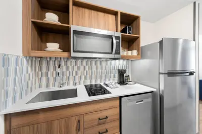 a kitchen with a stainless steel refrigerator and a microwave at Everhome Suites San Bernardino - Loma Linda in San Bernardino