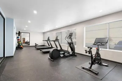 a gym with a row of exercise bikes and treadmills at Everhome Suites San Bernardino - Loma Linda in San Bernardino