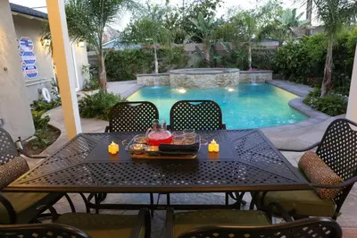 a table with a tray of food and candles on it next to a pool at Highly Upgraded, 5 Bed, 45 ba, New Pool w/Jacuzzi, 1/2 mile walk to Disney in Anaheim