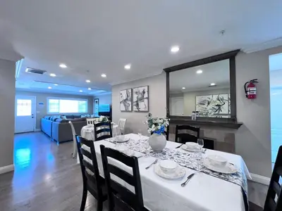 a dining room with a table and a living room at Stunning 8 bedroom 6 bathroom Pool Home in Anaheim