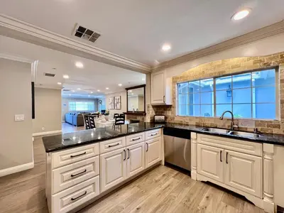 a kitchen with white cabinets and a large window at Stunning 8 bedroom 6 bathroom Pool Home in Anaheim