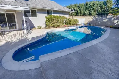 a swimming pool in the driveway of a house at Gorgeous Upgraded 5 Bedroom & 3 Bath Home with pool in Orange