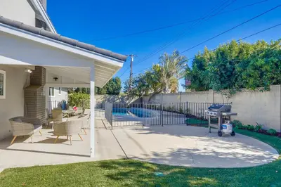 a patio with chairs and a grill in a yard at Gorgeous Upgraded 5 Bedroom & 3 Bath Home with pool in Orange
