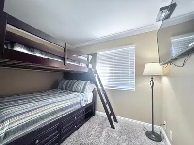 a bedroom with a bunk bed with a ladder at Luxurious 2 Bedroom Condo Shortest Walk To Disney in Anaheim