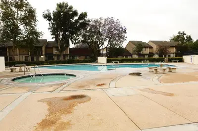 an empty swimming pool with picnic tables and benches at Luxurious 2 Bedroom Condo Shortest Walk To Disney in Anaheim