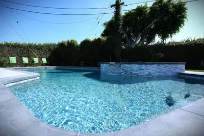 a swimming pool with blue water in a yard at Awesome 5 bedroom 3 bath pool home with in-ground jacuzzi in Orange
