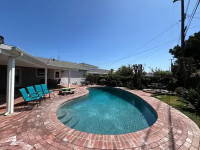 a swimming pool with blue chairs and a patio at Anaheim California, Beautiful Pool Home, Short Walk to Disney in Anaheim