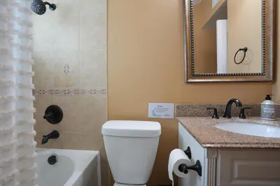 a bathroom with a toilet and a sink and a mirror at Sweet 4 bedroom, 3 bath plus Loft Bedroom, Pool Home in Anaheim