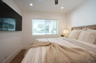 a white bedroom with a large bed and a window at 4 bedroom, 2 bathrooms in Orange