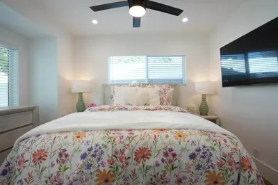 a bedroom with a large bed and two windows at 4 bedroom, 2 bathrooms in Orange