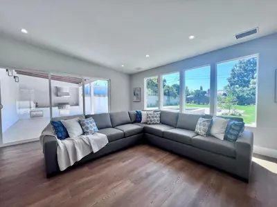 a large couch in a living room with windows at 4 bedroom, 2 bathrooms in Orange