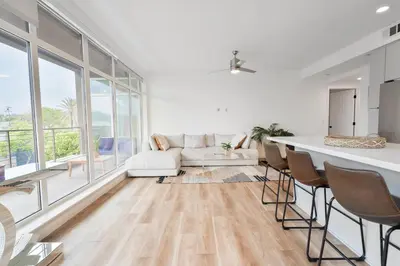 a living room with a white couch and a table at Glam by the Hollywood Sign 2 Bed Apt WITH FREE EV PARKING, Pool, Gym in Los Angeles