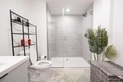 a bathroom with a toilet and a shower and a plant at Glam by the Hollywood Sign 2 Bed Apt WITH FREE EV PARKING, Pool, Gym in Los Angeles
