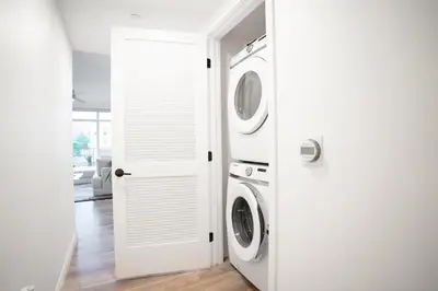a white laundry room with two washer and dryer at Glam by the Hollywood Sign 2 Bed Apt WITH FREE EV PARKING, Pool, Gym in Los Angeles