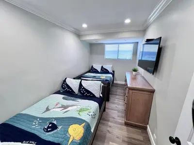 two beds in a room with a desk and a tv at 5 Bedroom plus loft room, 3 Bath home in Fullerton