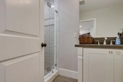 a white bathroom with a shower and a sink at 5 Bedroom plus loft room, 3 Bath home in Fullerton