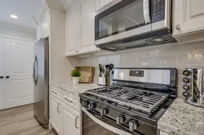 a kitchen with a stove and a microwave at 5 Bedroom plus loft room, 3 Bath home in Fullerton