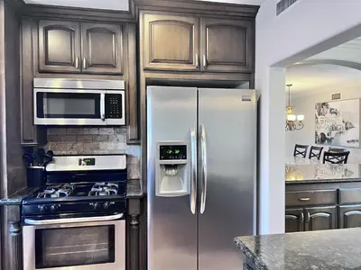 a kitchen with a stainless steel refrigerator and a stove at Gorgeous Pool Home 1/2 Mile Walk to Disney in Anaheim