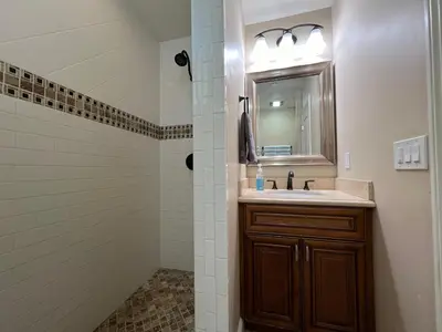 a bathroom with a sink and a mirror and a shower at Gorgeous Pool Home 1/2 Mile Walk to Disney in Anaheim