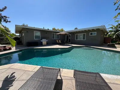a swimming pool in front of a house at Gorgeous Pool Home 1/2 Mile Walk to Disney in Anaheim