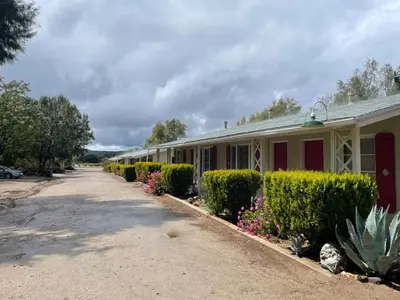 a building with bushes and flowers in front of it at Sierra Pelona Motel in Santa Clarita