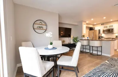 a dining room and kitchen with a white table and chairs at Pacific Blue Townhome Walk to Ocean 2 Bed Apt WITH FREE PARKING in Los Angeles
