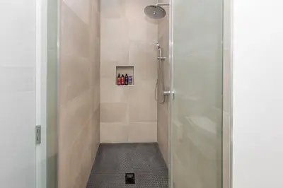 a bathroom with a shower with a glass door at Modern 2BR Back House w/ TVs & Full Kitchen in Los Angeles