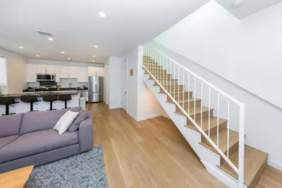 a living room with a couch and a staircase at Modern 2BR Back House w/ TVs & Full Kitchen in Los Angeles