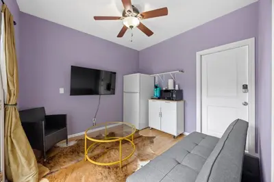 a living room with purple walls and a ceiling fan at Cozy Backhouse Stay – Sleeps 2 Beverly Hills Adj in Los Angeles