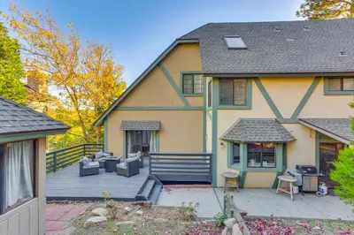 a house with a large deck with furniture on it at Partial Lake Arrowhead View Cabin with Game Room! in Lake Arrowhead