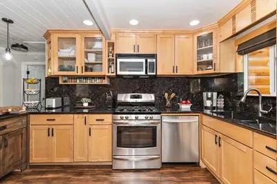 a kitchen with wooden cabinets and stainless steel appliances at Serenity Nook in Big Bear with a Hot Tub in Big Bear Lake