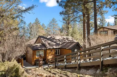 a log cabin in the woods with a fence at Serenity Nook in Big Bear with a Hot Tub in Big Bear Lake