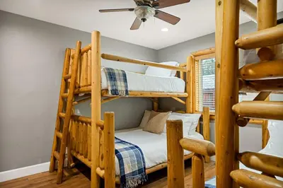 a room with two bunk beds and a ceiling fan at Llama Bear Lodge with Hot Tub in Big Bear Lake