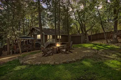 a house with a picnic table in the yard at Eureka Ranch Designer Cabin in Big Bear Lake