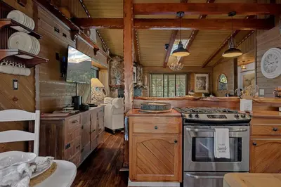 a kitchen with wooden cabinets and a stove top oven at Eureka Ranch Designer Cabin in Big Bear Lake