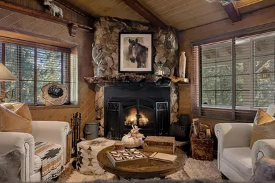 a living room with a fireplace in a log cabin at Eureka Ranch Designer Cabin in Big Bear Lake