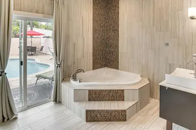 a bathroom with a tub next to a pool at Private Pool and Sauna Pet-Friendly Reseda Retreat! in Reseda