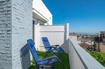two blue chairs sitting on the side of a house at Newly Remodeled Cozy Beach Retreat Ocean Views in Manhattan Beach