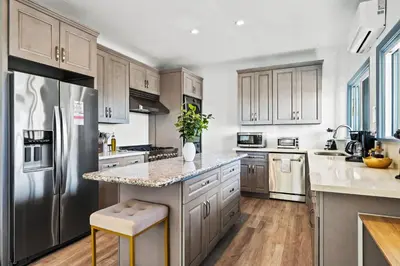 a kitchen with stainless steel appliances and wooden cabinets at 2BR Luxury Getaway Mins to Beach Arcade & Games in Manhattan Beach