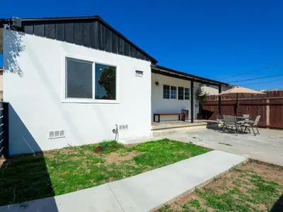 a white house with a patio and a fence at Gated & remodeled 2b2b house 3373 in Baldwin Park